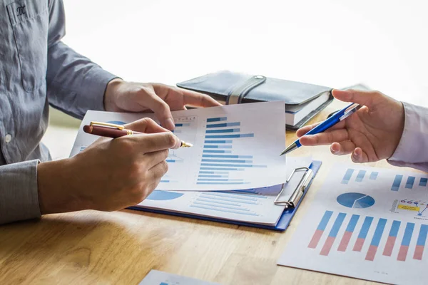 Business people meeting point to discuss, plan and chart the rise and fall of economic on white background.