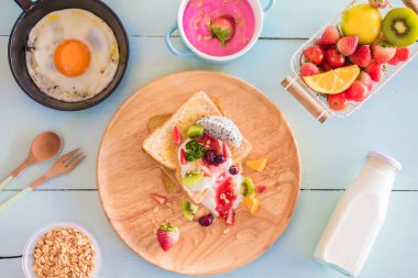 Kızarmış ekmek ve meyveli yoğurt, çırpılmış yumurta ve ahşap manzaralı tava..