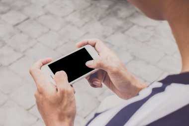 Yoldaki metin mesajınız için boş kopya alanı olan oyun cep telefonunu tutan adamın ellerini kapat, Vintage tonu. Seçmeli odak