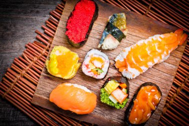 Suşi Sashimi ve suşi ruloları ahşap tahtada servis edilir.