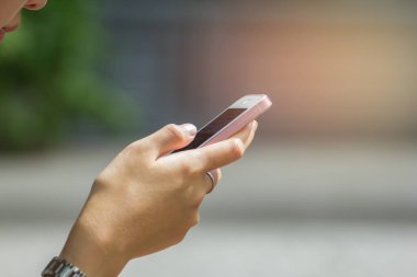 Parkta ışık günbatımlı, klasik tonlu mesajınız için elleriniz boş fotokopi alanı olan cep telefonuna dokunan erkeklerin ellerini kapatın.