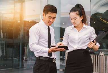 İş adamı ve kadın tablet kullanıyor. Reklamdaki ticari faaliyetlerle buluşuyor. Birlikte karşılıklı fayda sağlayacağız. Dışarıda.