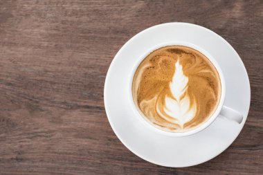 Kahve fincanı latte sanatı tahtada. Metnin için boşluk kopyala