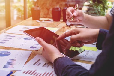 İş kurun. Insanlar ekonomi yukarı ve aşağı grafik tartışmak ve tablet Seçici Odaklanma üzerinde çalışmak için çalışma noktası