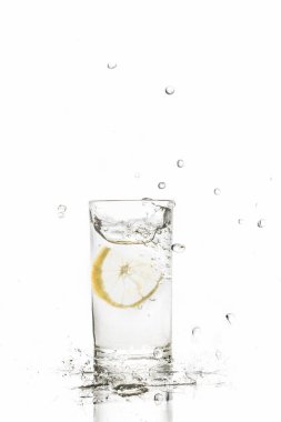 Beyaz arka planda izole edilmiş su bardağına limon sıçraması