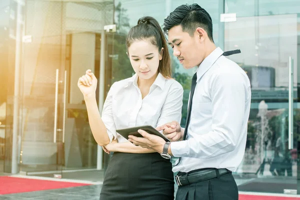 businessman and woman using tablet of working. Meetings promoting. Together create a mutually beneficial,They had made an agreement that they would share the profits equally.outside