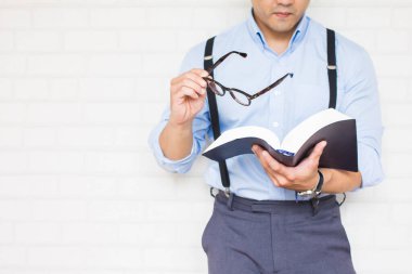 Yarı uzunlukta, mavi gömlekli adam elinde İncil 'in, Budist' in, Katolik 'in, Hıristiyan' ın, duanın kara kitabı var..