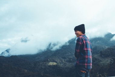 İskoç gömlekli ve siyah şapkalı Asyalı genç bulutların tepesinde dağ yürüyüşü ve dışarıda sis Hiker. Doi Luang Chiang Dao Chiangmai Eyaleti, Sabah.