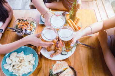 İki Asyalı kadın ve bir erkek. Bira içiyorlar, gülümsüyorlar. Grup kutlama partisi, mutlu yemek, konsept.