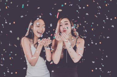 Konfeti hazırlayan iki Asyalı genç bayandan oluşan bir kutlama partisi grubu. 2018 'de yeni yıl tatili.