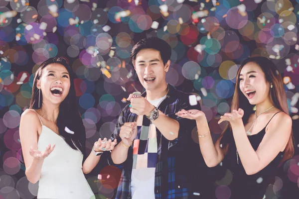 celebration party group of Two asian young man and women people holding confetti happy and funny concept