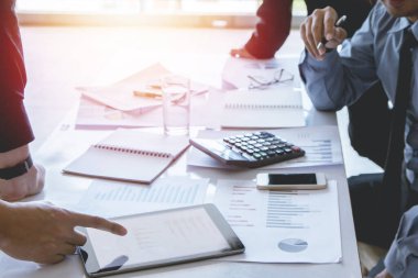 İş kurun. Insanlar ekonomi yukarı ve aşağı grafik tartışmak ve tablet üzerinde çalışmak için çalışma noktası Seçici Odaklanma