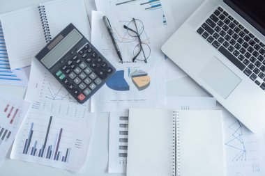 Üst görünüm ofis masası dizüstü bilgisayarı, malzemeleri ve sıcak kahvesi, grafik kağıdı, hesap makinesi. Metin için kopyalama alanı