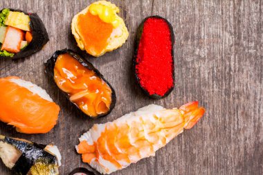 Üst Manzara, Sushi Sashimi ve suşi ruloları ahşap levhada servis edilir. Metnin için alanı kopyala.