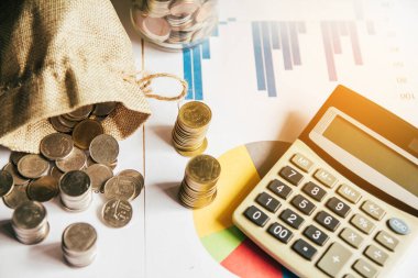 Günbatımının arka planında hafif günbatımına sahip gümüş paralar masanın üzerine yerleştirildi.