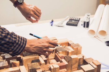 Konsept mimarlar, elinde kalem tutan mühendis ve sunum projektörleri ofiste bir planla birlikte masanın üzerinde, Vintage, Sunset Light. Seçici Odaklanma