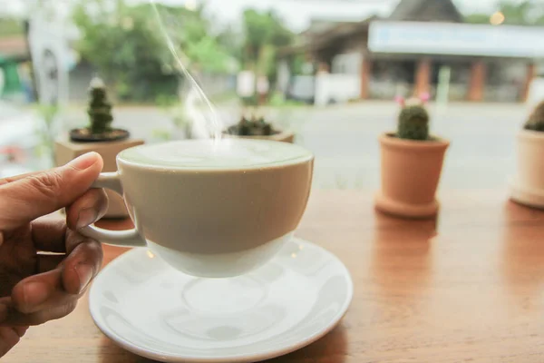 男ホールディングカップの緑茶ラテで午前中にコーヒーショップ — ストック写真