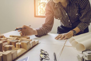 Mimarlar, mühendis elinde kalem tutan ekipman mimarları ofiste bir planla, Vintage, Sunset Light. Seçici Odaklanma