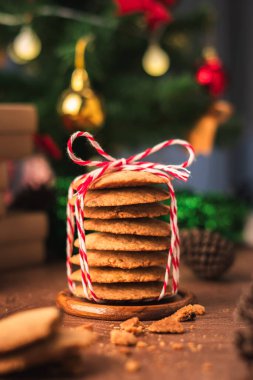 Şenlikli iple sarılmış el yapımı kurabiyeler, Noel ve yeni yıl ruhunu yakalıyor samimi, dikey tatil fotoğrafı konseptiyle mükemmel bir hediye olarak..