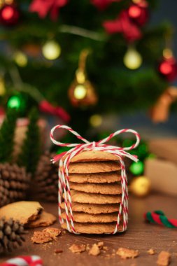Şenlikli iple sarılmış el yapımı kurabiyeler, Noel ve yeni yıl ruhunu yakalıyor samimi, dikey tatil fotoğrafı konseptiyle mükemmel bir hediye olarak..
