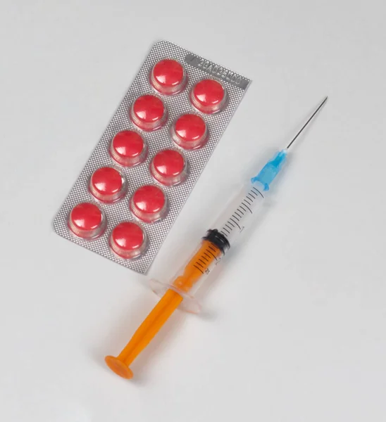 Czerwone Tabletki Blistrze Strzykawka Igłą Szarym Tle Zdjęcie Temat Medyczny — Zdjęcie stockowe