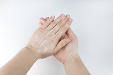 Kadın eli kremi sürükler. Kuru ciltte el kremi. Kendine dikkat et. Beyaz arka planda iki el.