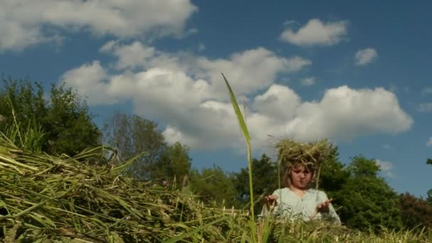 Szőke lánya, ha a gazdálkodó sző készült szalma koszorút — Stock videók