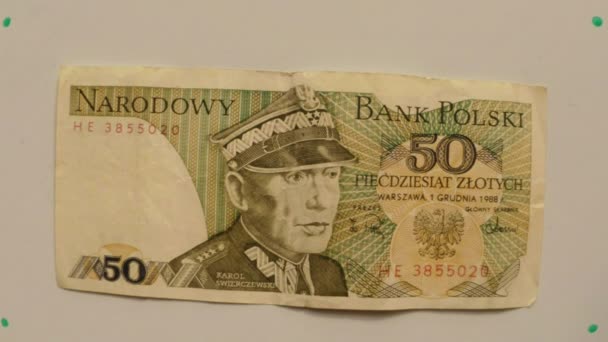 Papel moneda 50 zloty, Polonia en 1988 sobre una mesa blanca volteó una mano de cerca Karol Swierczewski retrato — Vídeo de stock