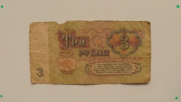 Papier monnaie de l'URSS 3 roubles sur une table blanche retourné une main de près 
