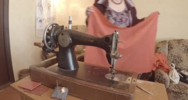 Büyükanne Sovyetler Birliği retro bir eski dikiş makinesinde bir kırmızı bayrak diker, tüm koleksiyon - birçok süper yakın çekimler, renk düzeltme için Raw formatta görmek