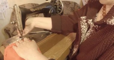 Büyükanne Sovyetler Birliği retro bir eski dikiş makinesinde bir kırmızı bayrak diker, tüm koleksiyon - birçok süper yakın çekimler, renk düzeltme için Raw formatta görmek