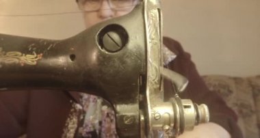 Büyükanne Sovyetler Birliği retro bir eski dikiş makinesinde bir kırmızı bayrak diker, tüm koleksiyon - birçok süper yakın çekimler, renk düzeltme için Raw formatta görmek