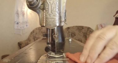 Büyükanne Sovyetler Birliği retro bir eski dikiş makinesinde bir kırmızı bayrak diker, tüm koleksiyon - birçok süper yakın çekimler, renk düzeltme için Raw formatta görmek