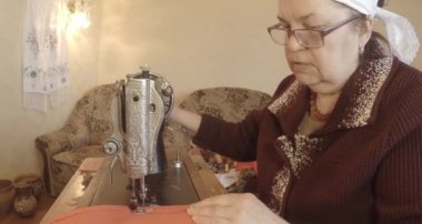 Büyükanne Sovyetler Birliği retro bir eski dikiş makinesinde bir kırmızı bayrak diker, tüm koleksiyon - birçok süper yakın çekimler, renk düzeltme için Raw formatta görmek