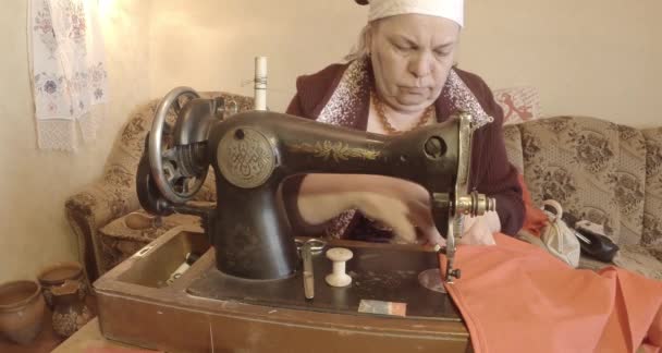 Grootmoeder naait een rode vlag op een oude naaimachine van de Sovjet-Unie retro, Bekijk de volledige collectie - vele super close-ups, Raw formaat voor kleurcorrectie — Stockvideo