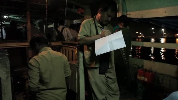 Моряк управляет шумным двигателем на индийской лодке ночью . — стоковое видео