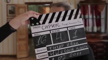 Film clapper, tarihi bir bina içinde bir kravat kelebek ile 19. yüzyıl kostüm hizmetçi