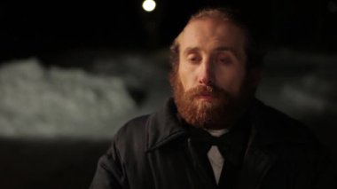 Rus sakallı adam bir takım elbise ve kravat kış, gece bir arka plan üzerinde