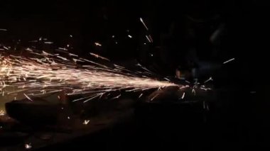 Sihirbaz bir metal davul sihirli sparks bir eski gaz çanta sonuçları yüzey parlatma üretimi için gaz çanta metal yüzey temizler çalışan karanlık bir garajda açı değirmeni grev kıvılcım