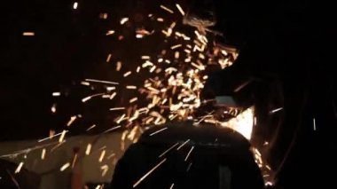 Sihirbaz bir metal davul sihirli sparks bir eski gaz çanta sonuçları yüzey parlatma üretimi için gaz çanta metal yüzey temizler çalışan karanlık bir garajda açı değirmeni grev kıvılcım