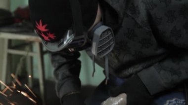 Sihirbaz bir metal davul sihirli sparks bir eski gaz çanta sonuçları yüzey parlatma üretimi için gaz çanta metal yüzey temizler çalışan karanlık bir garajda açı değirmeni grev kıvılcım