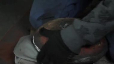 Sihirbaz bir metal davul sihirli sparks bir eski gaz çanta sonuçları yüzey parlatma üretimi için gaz çanta metal yüzey temizler çalışan karanlık bir garajda açı değirmeni grev kıvılcım