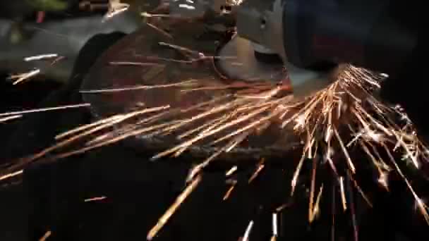 Winkelschleifer schlagen Funken in einer dunklen Garage läuft der Assistent für die Herstellung einer Metalltrommel magische Funken Polieren der Oberfläche eines alten Gasbeutels Ergebnisse reinigt die Metalloberfläche des Gasbeutels — Stockvideo