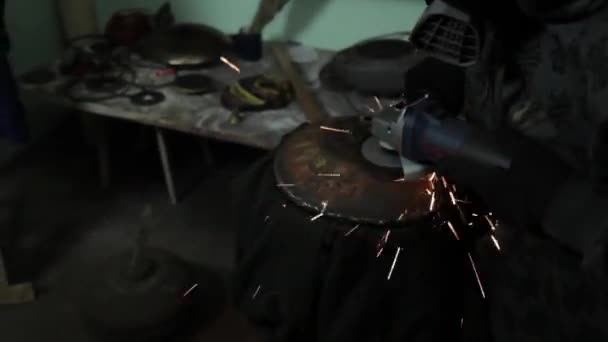 Angle Grinder grève étincelles dans un garage sombre exécutant l'assistant pour la production d'un tambour en métal étincelles magiques polissage de la surface d'un vieux sac à gaz résultats nettoie la surface métallique du sac à gaz — Video