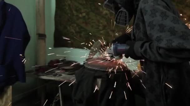 Angle Grinder grève étincelles dans un garage sombre exécutant l'assistant pour la production d'un tambour en métal étincelles magiques polissage de la surface d'un vieux sac à gaz résultats nettoie la surface métallique du sac à gaz — Video