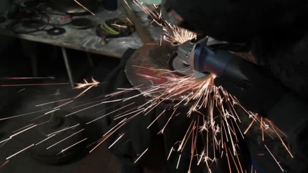 Angle Grinder grève étincelles dans un garage sombre exécutant l'assistant pour la production d'un tambour en métal étincelles magiques polissage de la surface d'un vieux sac à gaz résultats nettoie la surface métallique du sac à gaz — Video