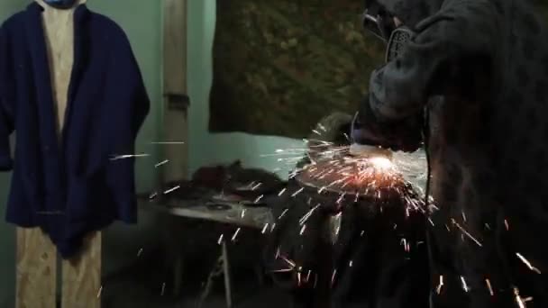 Angle Grinder strike sparks in a dark garage running the wizard for the production of a metal drum magic sparks polishing the surface of an old gas bag results cleans the metal surface of the gas bag — Stock Video