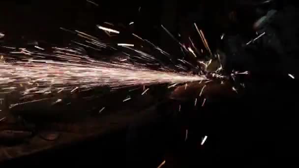 アングル グラインダー殴打のガス袋の金属表面をきれいに古いガス袋結果の表面を研磨金属ドラム魔法の火花の生産のためのウィザードを実行している暗いガレージで火花します。 — ストック動画