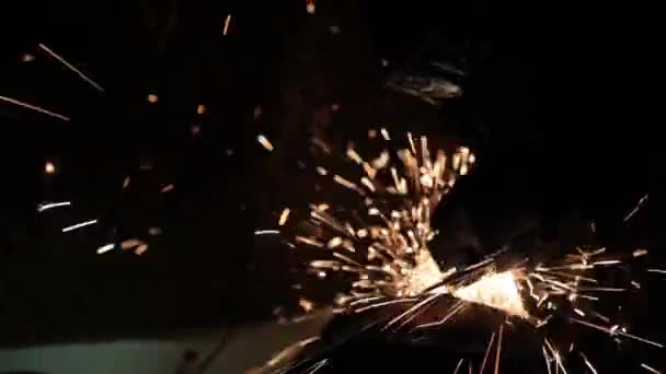 Winkelschleifer schlagen Funken in einer dunklen Garage läuft der Assistent für die Herstellung einer Metalltrommel magische Funken Polieren der Oberfläche eines alten Gasbeutels Ergebnisse reinigt die Metalloberfläche des Gasbeutels — Stockvideo