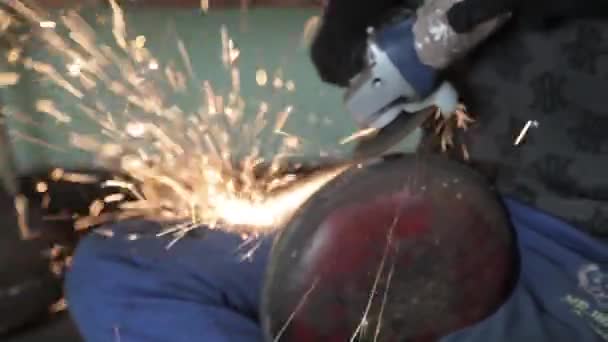 Angle Grinder grève étincelles dans un garage sombre exécutant l'assistant pour la production d'un tambour en métal étincelles magiques polissage de la surface d'un vieux sac à gaz résultats nettoie la surface métallique du sac à gaz — Video